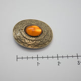 Vintage Gold‑Tone Ornate Brooch – Engraved Border & Amber Cabochon Center