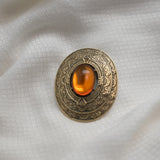 Vintage Gold‑Tone Ornate Brooch – Engraved Border & Amber Cabochon Center