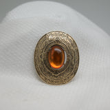 Vintage Gold‑Tone Ornate Brooch – Engraved Border & Amber Cabochon Center